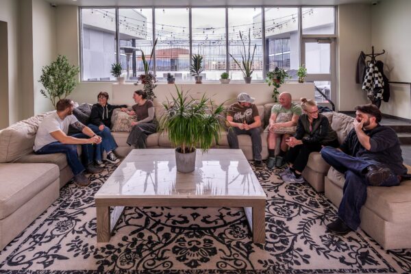 Patients sitting and talking on the co-ed common area’s sectional couch